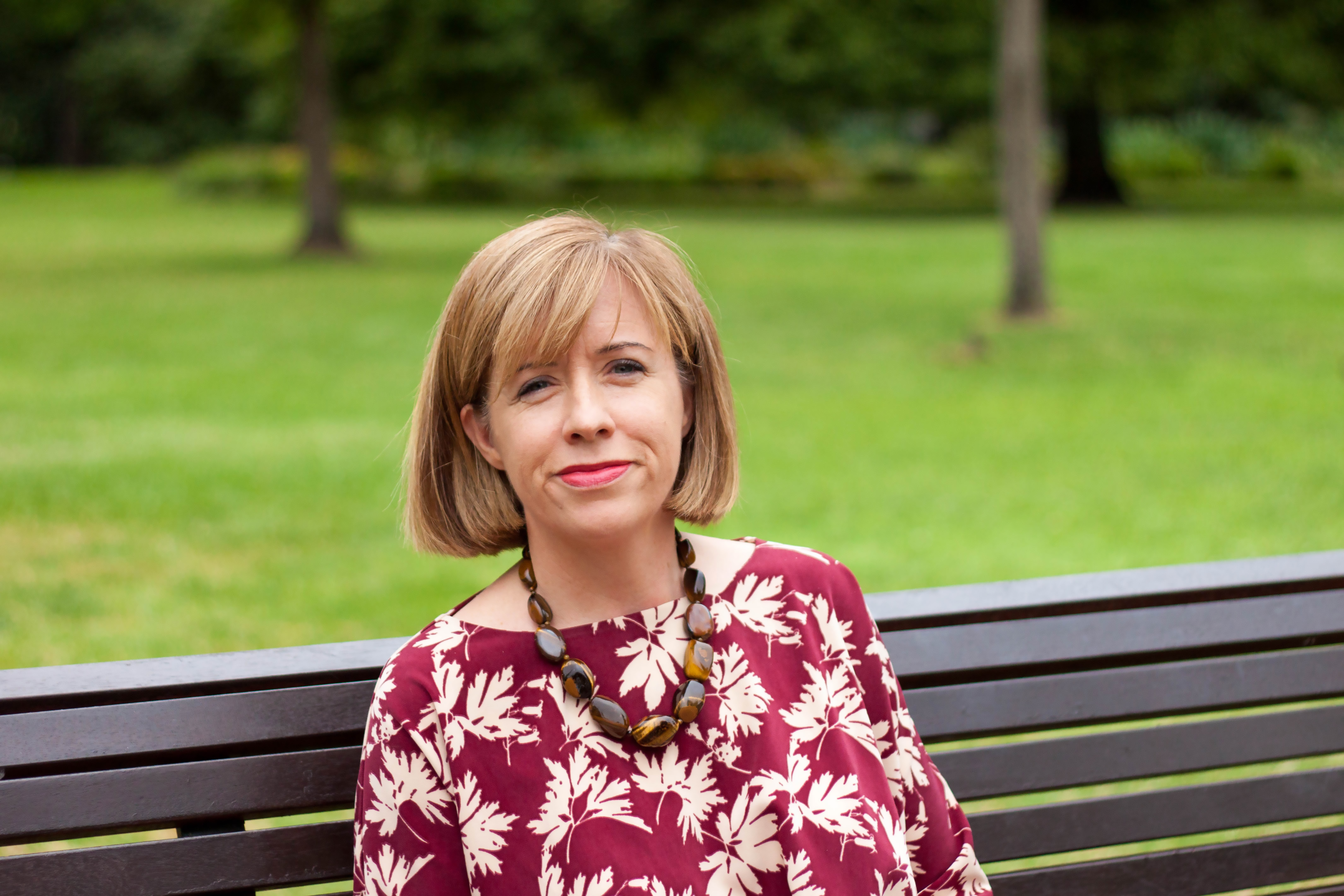 Image of incoming Commissioner Elizabeth Langdon sitting on a bench in a park.